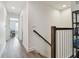 Upstairs hallway with wood floors and a wood-trimmed banister along the stairs at 17880 Althea Blue Pl, Lutz, FL 33558