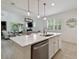 Bright, open kitchen and dining area featuring a large island and modern light fixtures at 17880 Althea Blue Pl, Lutz, FL 33558