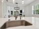 Close-up of a kitchen island with a sink, sleek faucet, and view into the living area at 17880 Althea Blue Pl, Lutz, FL 33558