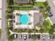 Aerial view of a well-maintained community pool area with lounge chairs, landscaping, and parking spaces at 17880 Althea Blue Pl, Lutz, FL 33558