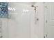 Clean glass shower with white tile and modern shower head at 17880 Althea Blue Pl, Lutz, FL 33558