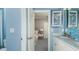 Connected bathroom and bedroom with blue walls and vanity, including blue-themed decorations and artwork at 1806 Longliner Loop, Wesley Chapel, FL 33543