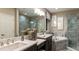 Luxurious bathroom with a marble-tiled shower, soaking tub, double vanity, and modern fixtures at 1806 Longliner Loop, Wesley Chapel, FL 33543