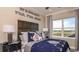 Themed bedroom with decorative pillows, a black nightstand, and a large window showcasing scenic views at 1806 Longliner Loop, Wesley Chapel, FL 33543