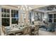 Open dining and living area with a decorative light fixture, large windows, and comfortable seating at 1806 Longliner Loop, Wesley Chapel, FL 33543