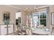Formal dining room with elegant chandelier and set table for a dinner party at 1806 Longliner Loop, Wesley Chapel, FL 33543