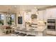 Kitchen area features white cabinets, granite countertop island with seating and stainless steel appliances at 1806 Longliner Loop, Wesley Chapel, FL 33543