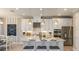 Kitchen area features white cabinets, granite countertop island with seating and stainless steel appliances at 1806 Longliner Loop, Wesley Chapel, FL 33543