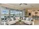 Open-concept living space features a comfortable sectional, floor-to-ceiling windows, and access to outdoor living at 1806 Longliner Loop, Wesley Chapel, FL 33543