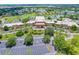 An aerial view of a sprawling community center, mature trees, parking lot and surrounding lakes at 201 Bedford St # 79, Sun City Center, FL 33573