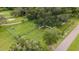 Aerial view of fenced dog park featuring grassy areas, play structures, and seating within a community park setting at 201 Bedford St # 79, Sun City Center, FL 33573