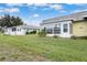 A bright single story home with an enclosed patio, a well manicured lawn and blue skies at 201 Bedford St # 79, Sun City Center, FL 33573