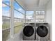 Sunlit Florida room with laundry setup, featuring large windows and checkered floor at 201 Bedford St # 79, Sun City Center, FL 33573