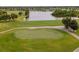 Scenic golf course view featuring lush green putting greens, a tranquil pond and mature trees at 201 Bedford St # 79, Sun City Center, FL 33573