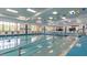 Bright indoor pool with blue and yellow accents, large windows, and safety features at 201 Bedford St # 79, Sun City Center, FL 33573