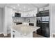 Modern kitchen featuring white cabinets, stainless steel appliances, a mosaic backsplash, and a spacious island at 201 Bedford St # 79, Sun City Center, FL 33573
