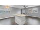 Bright living room with two windows, gray walls, wood flooring, and an island with white cabinets at 201 Bedford St # 79, Sun City Center, FL 33573