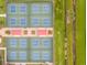 Aerial view of multiple pickleball courts, shaded seating, and beautiful landscaping at 201 Bedford St # 79, Sun City Center, FL 33573