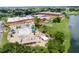Aerial view of community pool with ample seating, clubhouse, and lake in the background at 201 Bedford St # 79, Sun City Center, FL 33573