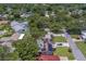 Aerial shot of house with solar panels surrounded by lush greenery and neighborhood at 2123 Indigo Dr, Clearwater, FL 33763