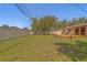 Large fenced backyard featuring a well-kept lawn and a cozy wooden deck at 2123 Indigo Dr, Clearwater, FL 33763