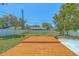 Large wooden deck and green backyard, surrounded by a white fence and mature trees, providing privacy at 2123 Indigo Dr, Clearwater, FL 33763