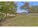 Spacious backyard showing lush grass, a wooden deck, and partial home view at 2123 Indigo Dr, Clearwater, FL 33763