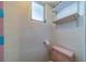 Modest bathroom featuring a pink toilet, a small window, and open shelving above the toilet at 2123 Indigo Dr, Clearwater, FL 33763