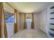 Bedroom with neutral walls, tile flooring, natural light from curtain-covered windows, and a closet at 2123 Indigo Dr, Clearwater, FL 33763