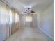 Bright bedroom with neutral walls, tile flooring, ceiling fan, and natural light from curtain-covered windows at 2123 Indigo Dr, Clearwater, FL 33763