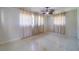 Spacious bedroom featuring neutral walls, tile flooring, and a modern ceiling fan with lighting at 2123 Indigo Dr, Clearwater, FL 33763