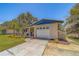Charming single-story home with a well-maintained lawn, complemented by trees and blue exterior accents at 2123 Indigo Dr, Clearwater, FL 33763