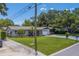 Charming home featuring a well-manicured lawn, vibrant landscaping, and a cozy front porch at 2123 Indigo Dr, Clearwater, FL 33763
