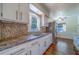 Bright kitchen featuring white cabinets, granite countertops, and stainless steel appliances at 2123 Indigo Dr, Clearwater, FL 33763