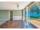 Bright living room with wood-look tile floors, wainscoting, and sliding glass doors to deck at 2123 Indigo Dr, Clearwater, FL 33763