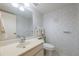 Cozy bathroom featuring a single sink vanity, neutral wallpaper, and a toilet at 2192 Swedish Dr # 26, Clearwater, FL 33763