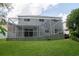 Two-story home with a screened-in lanai, backyard and lush green lawn at 25435 Bruford Blvd, Land O Lakes, FL 34639