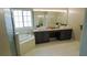 Bright bathroom featuring double sinks, neutral tile floor, soaking tub, and natural light from a large window at 25435 Bruford Blvd, Land O Lakes, FL 34639