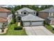 Two-story home with a gray exterior, white trim, a well-manicured lawn, and a two-car garage at 25435 Bruford Blvd, Land O Lakes, FL 34639