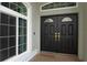 Close-up of a grand double front door with glass accents and brass hardware at 25435 Bruford Blvd, Land O Lakes, FL 34639