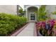 Inviting walkway to the home's entrance with lush landscaping and a charming front door at 25435 Bruford Blvd, Land O Lakes, FL 34639
