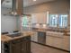 A kitchen with a black island, farm sink, and stainless steel appliances with natural light at 25435 Bruford Blvd, Land O Lakes, FL 34639