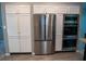 View of kitchen with white cabinets, stainless steel refrigerator and built-in ovens at 25435 Bruford Blvd, Land O Lakes, FL 34639