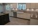 A kitchen with a black island, farm sink, and stainless steel appliances with natural light at 25435 Bruford Blvd, Land O Lakes, FL 34639