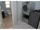 View from laundry room to the bathroom with modern sink, toilet, and bathtub with shower at 25435 Bruford Blvd, Land O Lakes, FL 34639