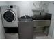 Laundry room with modern appliances and a stainless-steel utility sink at 25435 Bruford Blvd, Land O Lakes, FL 34639