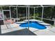 Screened-in pool featuring a cascading water feature, surrounded by lush greenery at 25435 Bruford Blvd, Land O Lakes, FL 34639