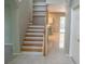 Staircase with wooden steps and railings, tile flooring, and a view into the kitchen area at 25435 Bruford Blvd, Land O Lakes, FL 34639