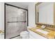 This is a bathroom featuring a black framed glass shower, and a granite countertop vanity with a gold framed mirror at 2746 Heathgate Way, Land O Lakes, FL 34638