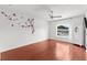 A bright bedroom has wood floors, white walls decorated with a cherry blossom design, a ceiling fan and a window view at 2746 Heathgate Way, Land O Lakes, FL 34638